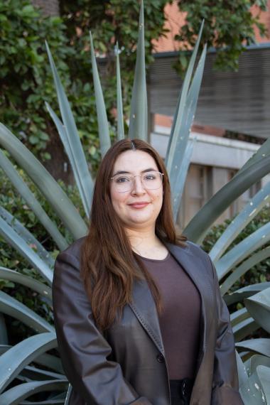 Camila Guadalupe Armenta headshot, wearing eyeglasses, brown blouse and brown blazer, agave plant in the background