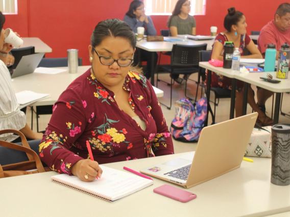 ITEP student taking notes during lesson with Dr. Norma Gonzalez