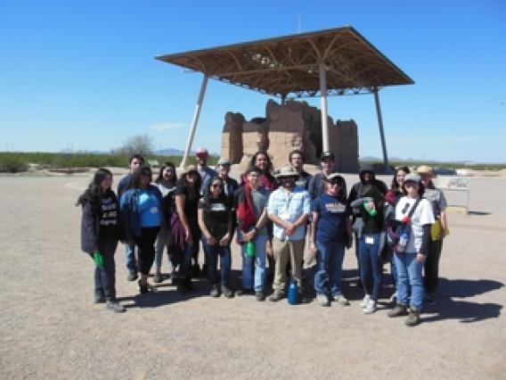 group of adults standing in front of an archaeological site