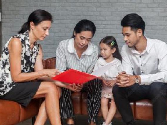 asian parents with child speaking with a family therapist