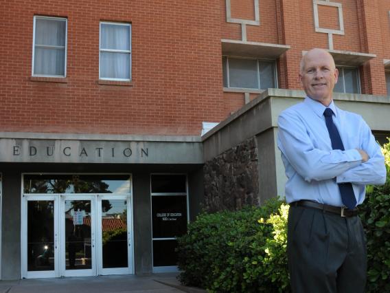 Dean Johnson posing in front of College of Education