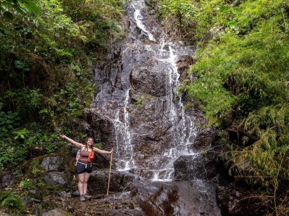 sarah rose standing in front of a waterfall in costa rica