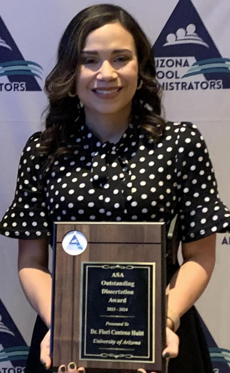 flori ceneno huit wearing a polka dot black and white blouse, holding her award