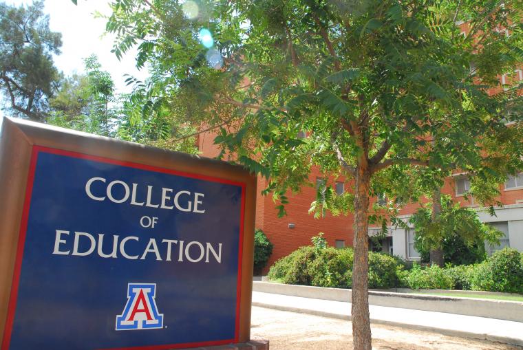 college of education sign with building in the background