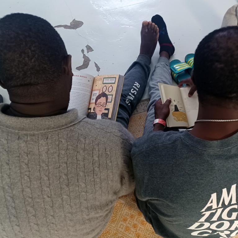 overhead view of two readers sitting on the floor with books in their hands