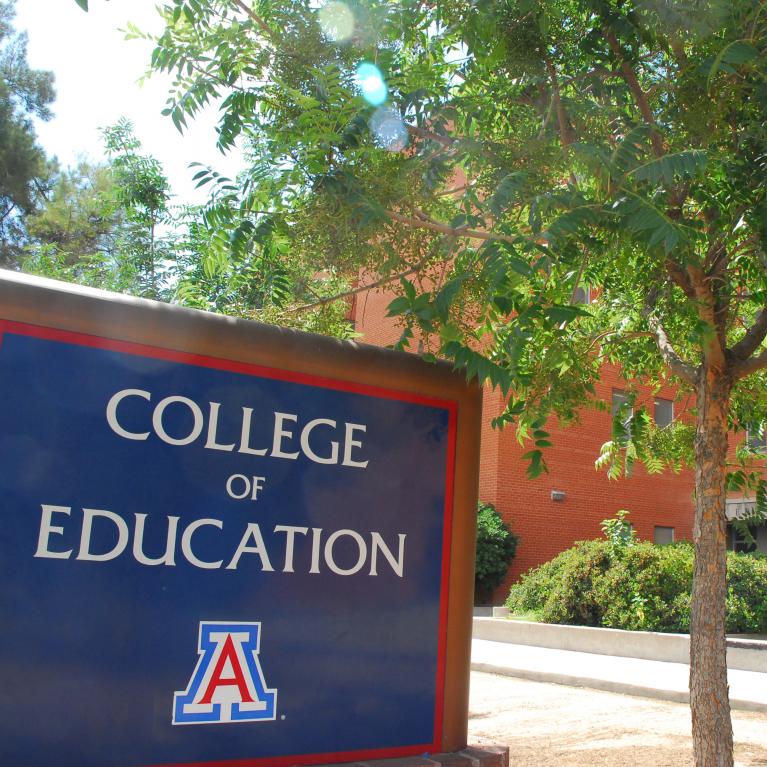 college of education sign with building in the background
