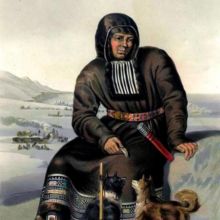itlemen sitting on a rock with two dogs at his feet