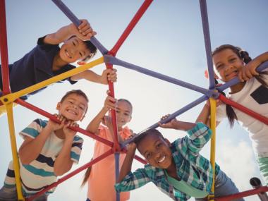 several kids looking down through playground structure